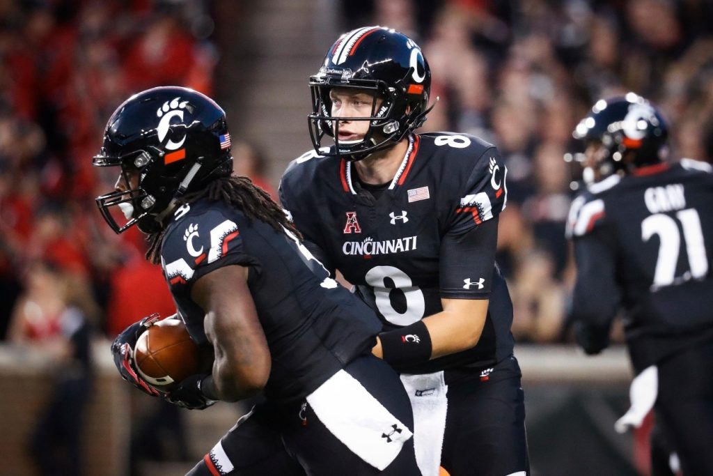 Cincinnati quarterback Hayden Moore hands off the ball to running back Mike Boone, left, during the first half of an NCAA college football game against Houston, Thursday, Sept. 15, 2016, in Cincinnati. (AP Photo/John Minchillo)