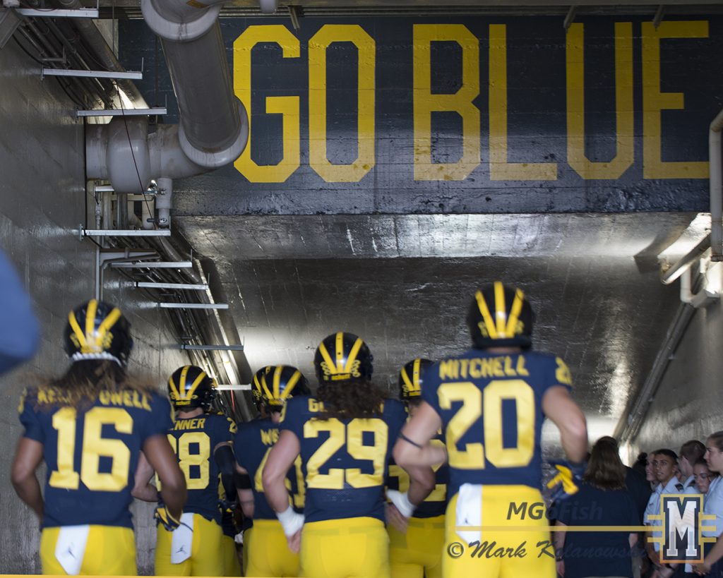 Michigan players running down the Big House tunnel under the Go Blue signs. Photo: Mark Kolanowski/MGoFish